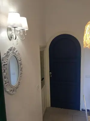a hallway with a blue door and a mirror at Le Lanterne di Terrasini in Terrasini