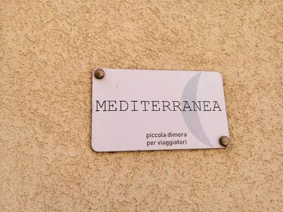 a white sign on the side of a wall at Mediterranea - Piccola Dimora per Viaggiatori in Castellammare del Golfo