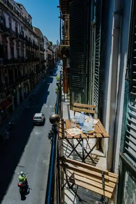 a table on the side of a building on a street at Calamarina Centro in Palermo