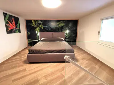a bedroom with a bed and a glass wall at Diatomea in Palermo