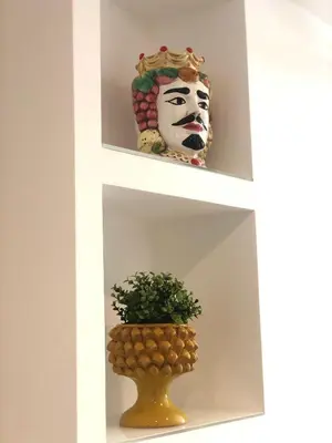 a shelf with a mask and a plant on it at B&B Angolo83 Palermo centro in Palermo