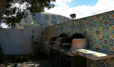 a group of chairs sitting next to a wall at Boa Vista San Vito - Area Fitness, Barbecue Area, Tennis Court in San Vito lo Capo
