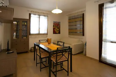 a kitchen and dining room with a table and chairs at Boa Vista San Vito - Area Fitness, Barbecue Area, Tennis Court in San Vito lo Capo