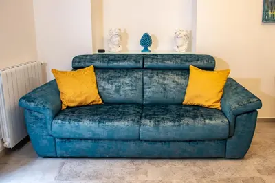 a blue couch with yellow pillows in a living room at Casta Diva Luxury Apartments -Self check-in in Palermo