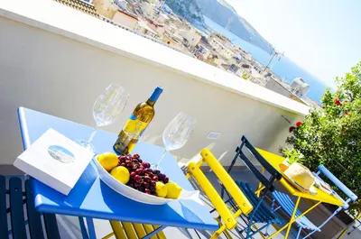 a table with a bowl of fruit and a bottle of wine at Solemare Casa Vacanze in Castellammare del Golfo