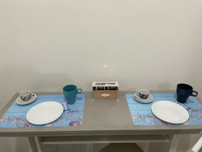 a table with two plates and cups on it at La casetta di Mavi in Palermo