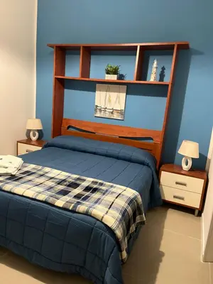 a bedroom with a bed with a blue wall at Josh's House Mondello in Mondello