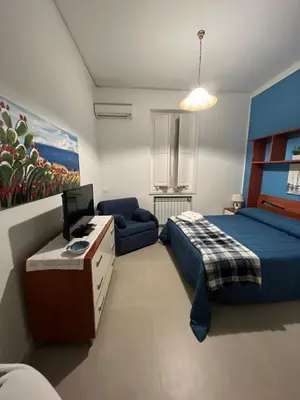 a bedroom with a bed and a desk with a computer at Josh's House Mondello in Mondello