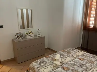 a bedroom with a bed and a dresser with a mirror at Casa Vacanze Costanza in San Vito lo Capo