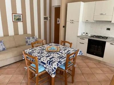 a kitchen with a table and chairs and a kitchen with a couch at Casa Vacanze Costanza in San Vito lo Capo