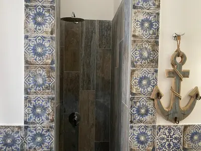 a bathroom with a shower with a anchor on the wall at Casa Vacanze Costanza in San Vito lo Capo