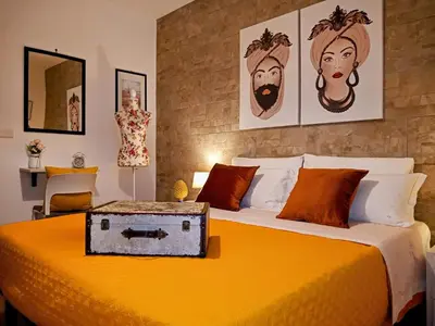 a bedroom with a yellow bed with a suitcase on it at Zisa Home ai Cantieri Culturali con Patio Privato - vicino centro storico - No ZTL in Palermo