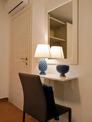 a room with a chair and a mirror and a table at Zisa Home ai Cantieri Culturali con Patio Privato - vicino centro storico - No ZTL in Palermo