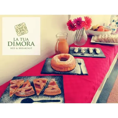 a table with a red table cloth with food on it at B&B La Tua Dimora in Palermo