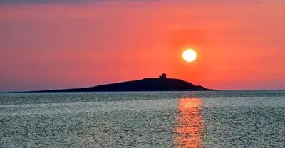 an island in the middle of the ocean with a sunset at B&B La Tua Dimora in Palermo