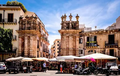 a street with tables and umbrellas in front of a building at B&B La Tua Dimora in Palermo