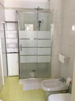 a bathroom with a glass shower and a toilet at Sofi apartment in Palermo