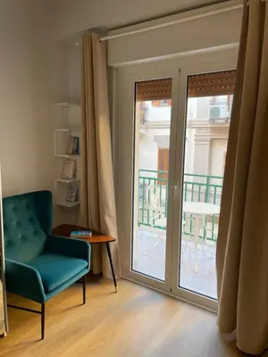 a room with a chair and a sliding glass door at Sofi apartment in Palermo