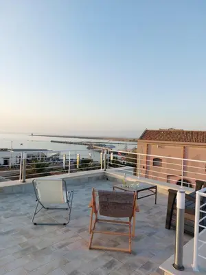 a patio with a table and a chair on a roof at A casa di nonna Maria in Terrasini