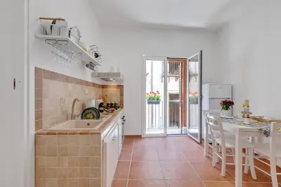 a kitchen with a sink and a table with chairs at GuestHost - Vucciria Market Apartment with Balconies in Palermo