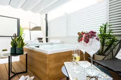 a bathroom with a tub and two glasses of wine at Dc Domus Charme SPA in Palermo