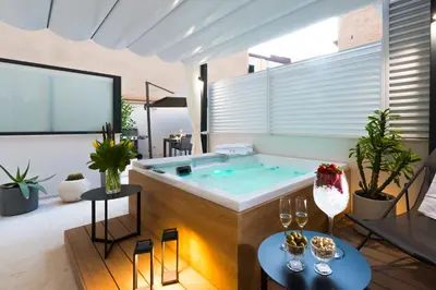 a hot tub in a living room with plants at Dc Domus Charme SPA in Palermo
