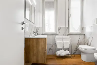 a bathroom with a sink and a toilet and windows at GuestHost - Residenza dei Poeti - Roomy and Modern Flat in Palermo