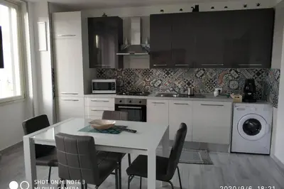 a kitchen with a white table and chairs and a table and a stove at Home sweet home appartamento ricco di comfort in Palermo
