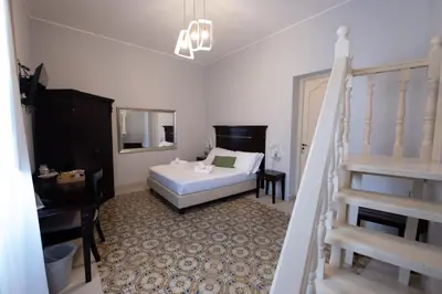 a bedroom with a bed and a staircase in it at Hotel Borgo di Ciàula in Santa Flavia