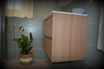 a bathroom with a wooden cabinet and a plant at PESCA AZZURRA in Terrasini