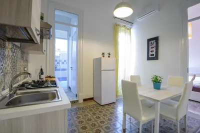 a kitchen with a sink and a table and a refrigerator at HouseStation in Palermo