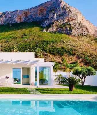 a villa with a swimming pool in front of a mountain at Golden Holiday Villas Private Pools in Sicily in Terrasini