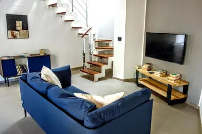 a living room with a blue couch and a tv at Le dimore di Palagonia in Bagheria