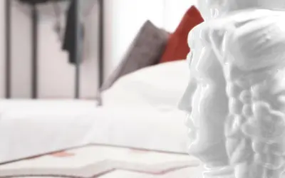 a white statue of a person standing next to a bed at Antista Rooms in Palermo
