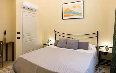 a bedroom with a white bed with two pillows at Antista Rooms in Palermo