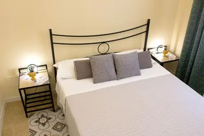 a bedroom with a large bed with two night stands at Antista Rooms in Palermo