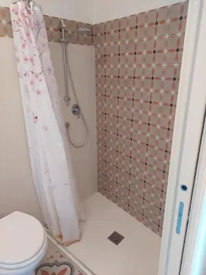 a bathroom with a shower curtain and a toilet at Antista Rooms in Palermo
