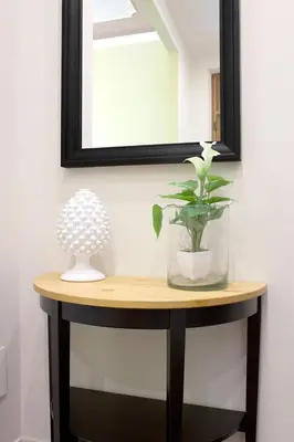 a table with a mirror and a vase with a plant on it at Antista Rooms in Palermo