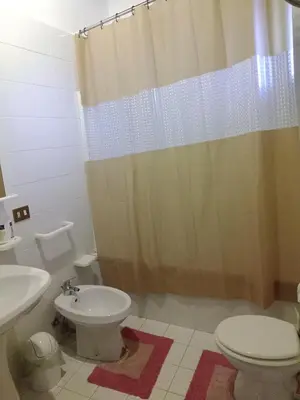 a white bathroom with a sink and a toilet at Casa vacanze Butterfly in Trabia