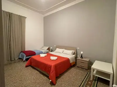 a bedroom with two beds and a red blanket at 100 PASSI al Massimo in Palermo
