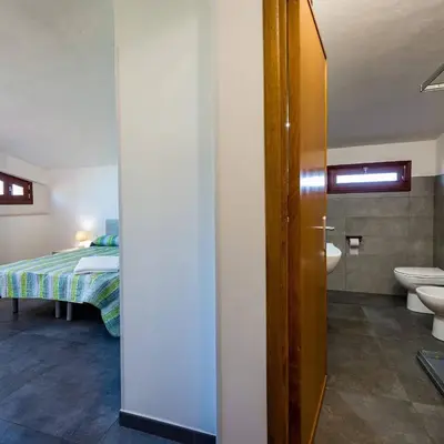 a bathroom with a bed and a toilet and a sink at Villa Michelangelo in Castellammare del Golfo