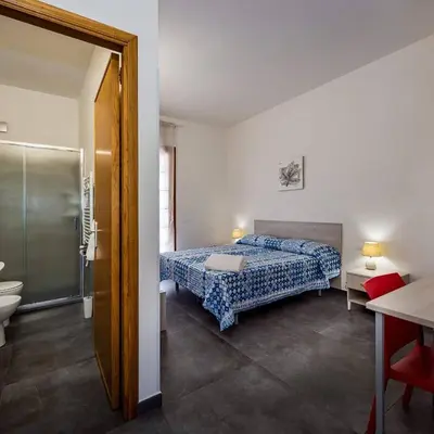 a bedroom with a bed and a bathroom with a shower at Villa Michelangelo in Castellammare del Golfo