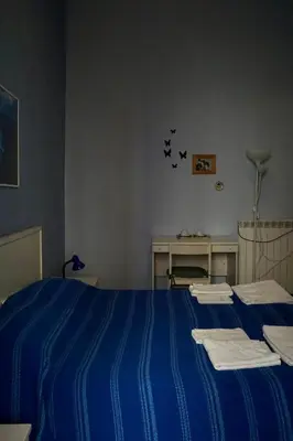 a bedroom with a blue bed with blue stripes at B&B Vivaldi in Palermo