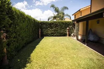 a garden with a hedge in front of a house at Dimora Fanale, Villa Esclusiva con Piscina Privata - Fanale Rentals in Altavilla Milicia