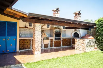 a patio with an outdoor kitchen in a house at Dimora Fanale, Villa Esclusiva con Piscina Privata - Fanale Rentals in Altavilla Milicia