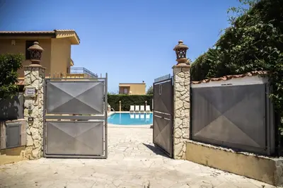 a pair of gates in front of a pool at Dimora Fanale, Villa Esclusiva con Piscina Privata - Fanale Rentals in Altavilla Milicia