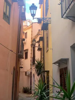 an alley in an old town with buildings and plants at Kemonia Home Palermo in Palermo