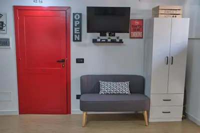 a red door next to a chair and a tv at Loft Mercede al Capo in Palermo