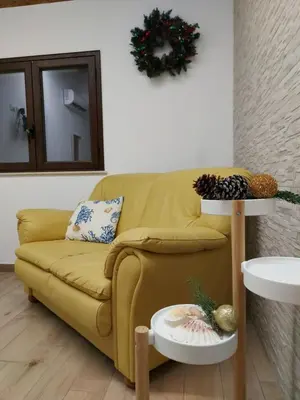 a living room with a yellow couch and a table at Terrazza del Golfo in Castellammare del Golfo