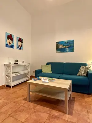 a living room with a blue couch and a coffee table at Piazza Marina Apartment in Palermo